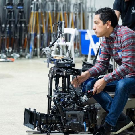 Man sits with camera on wheeled device
