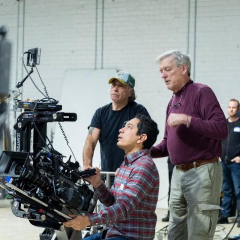 Man with camera demonstrates to students