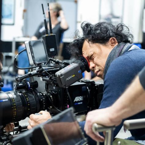 Man with camera demonstrates to students