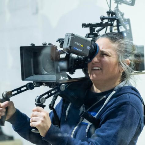 Woman with camera demonstrates to students