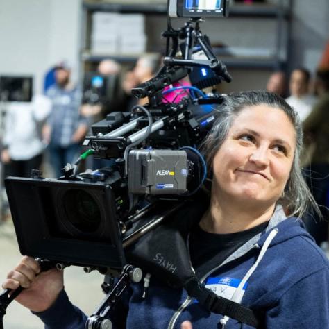 Woman with camera demonstrates to students
