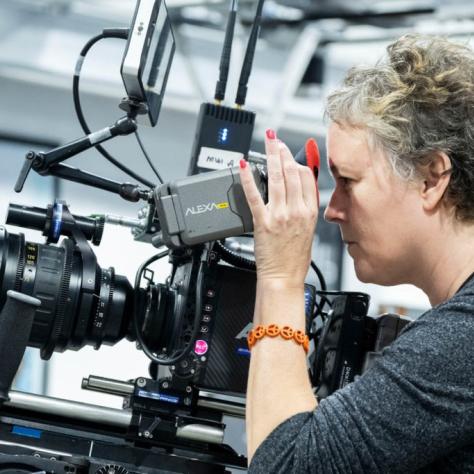 Woman with camera demonstrates to students