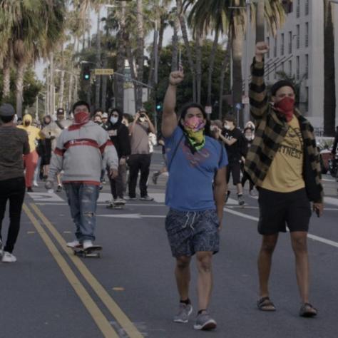 People marching in the street, a couple of them with fists in the air